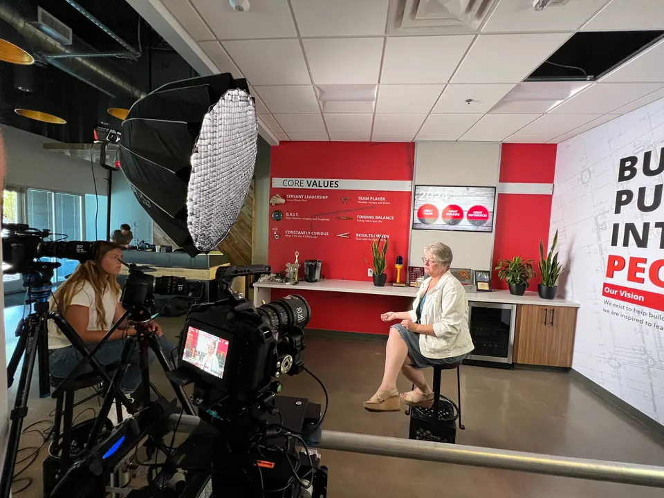 Camera operator framing an interview on the Briq testimonial set