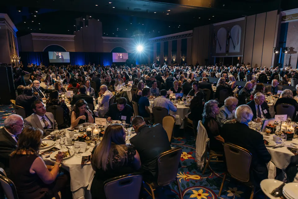 Packed tables of guests under the ballroom chandeliers