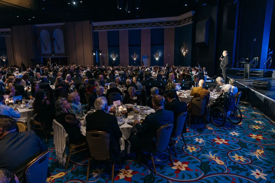 Audience at tables watching the stage