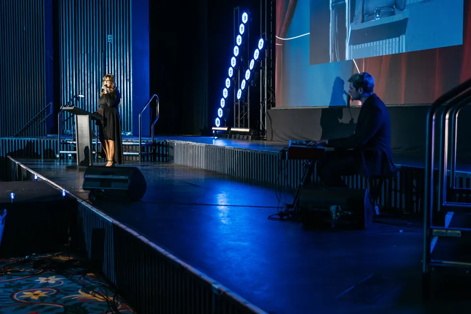 Speaker at a podium on the lit stage