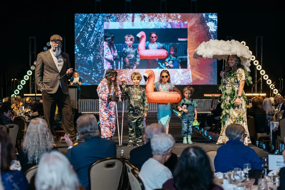 Fashion show participants posing on stage