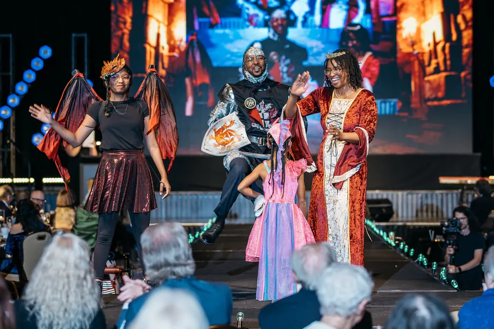 Kids and models in colorful costumes on the fashion show stage