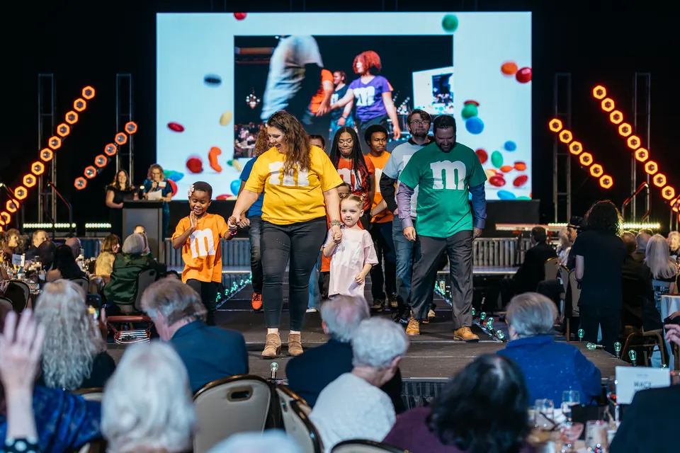 Young participants celebrating on stage in front of the video screen