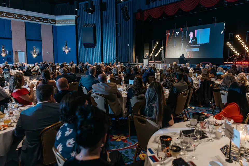 Ballroom crowd watching the show with the stage screen in view