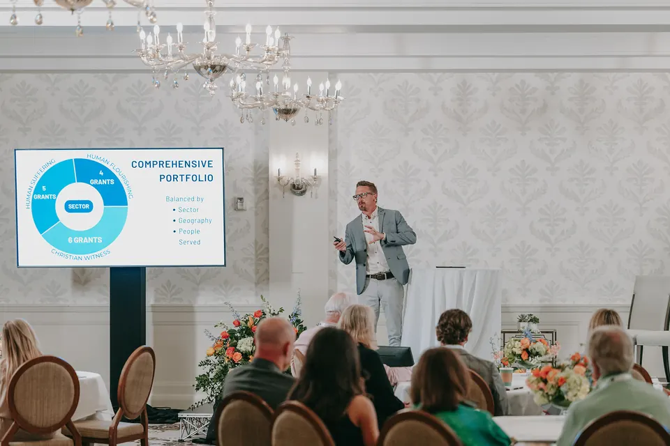 Presenter beside a slide on screen at the Kingdom Giving Fund Summit